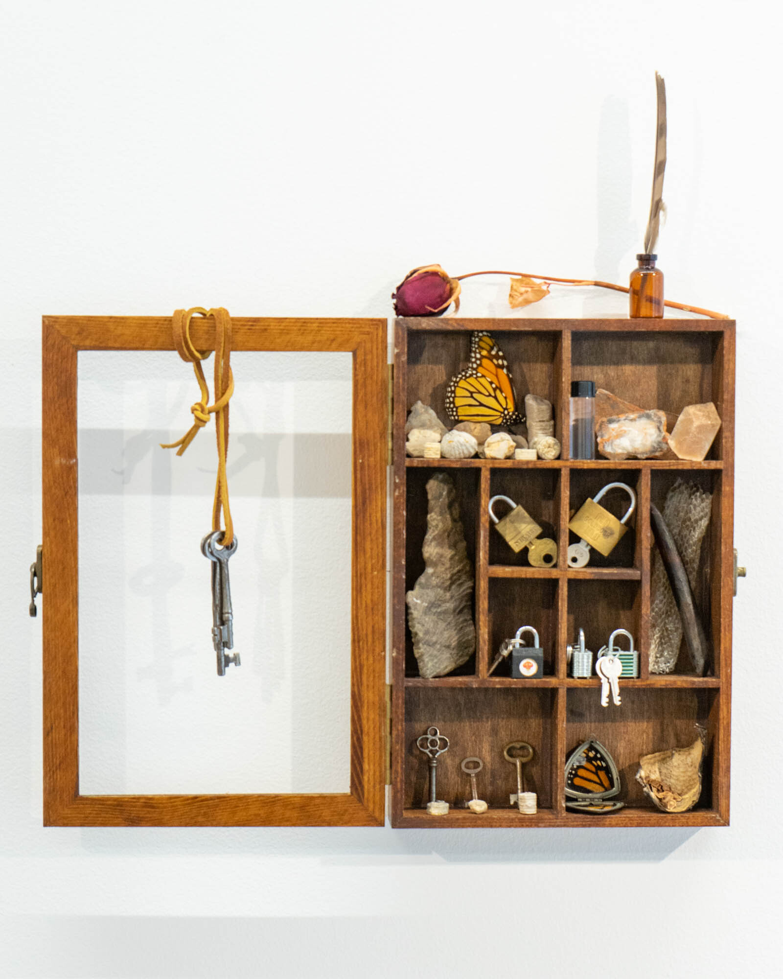 A Shadowbox Holds Stones Keys Locks And Other Small Items