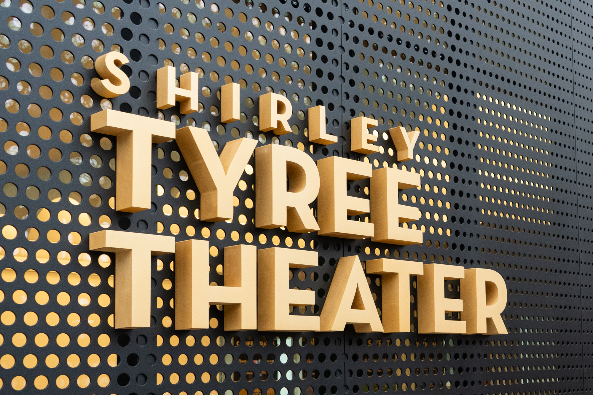 A close up of the metal sign of The Shirley Tyree Theater
