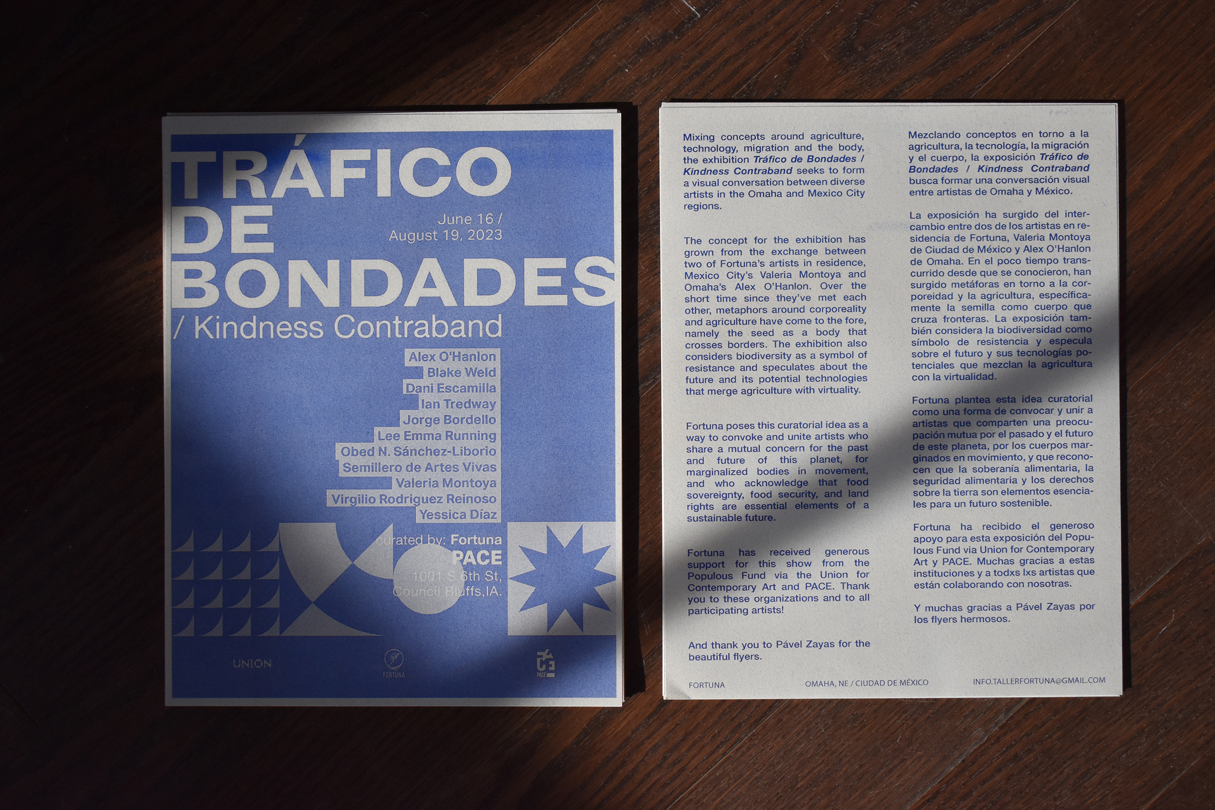 A gallery brochure with shaped light falling on it the title reads Trafico de Bondes in English Kindness Contraband