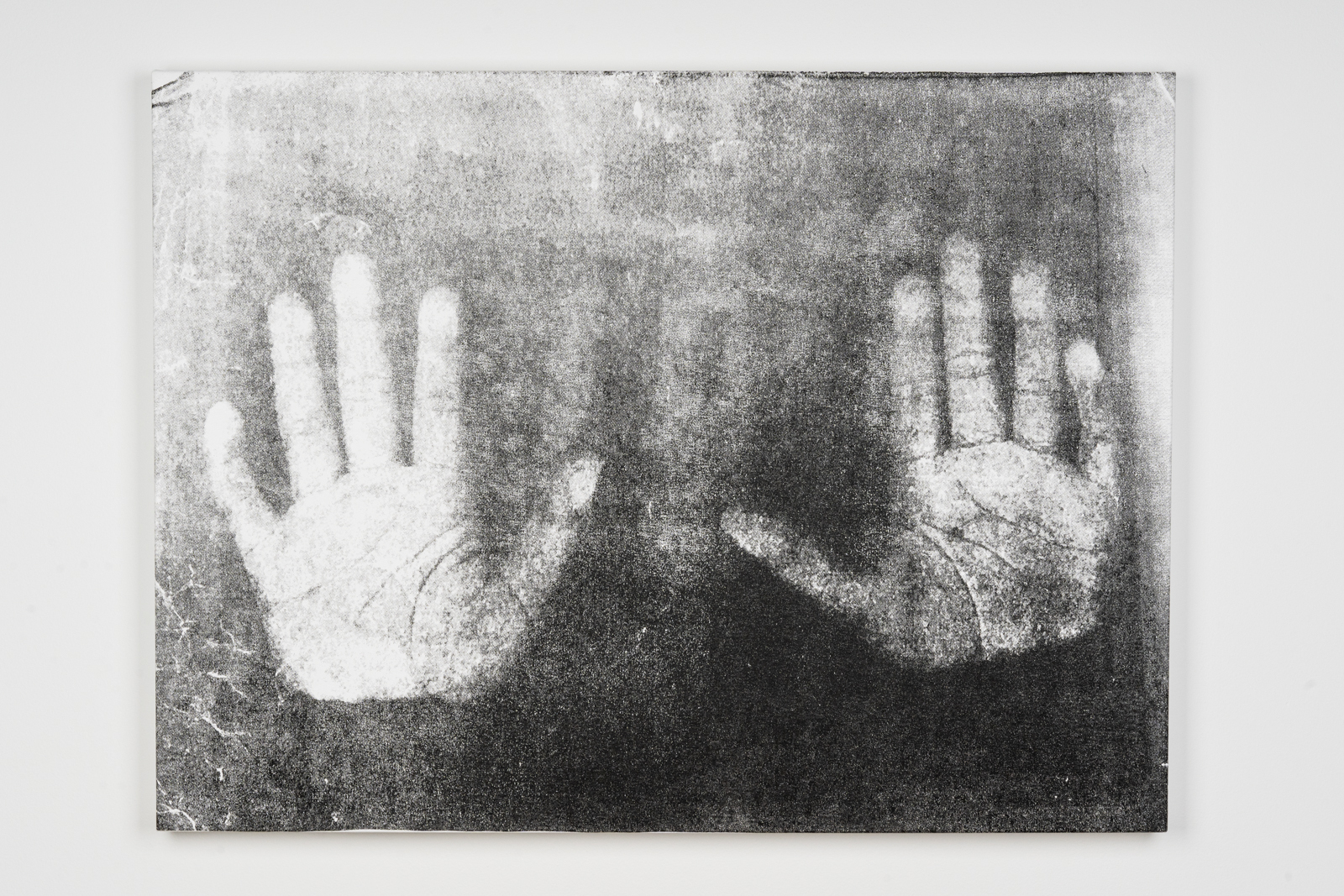 A large screenprint of two hands with palms facing the viewer by artist Leslie Diuguid