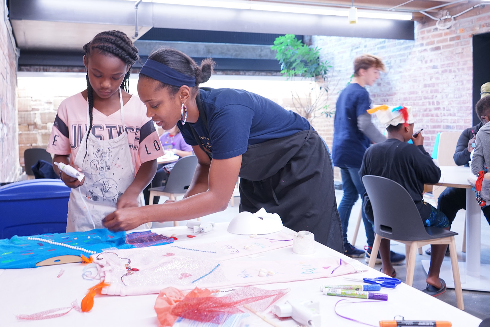 A young artist and her mother collaborate on a fabric collage during Family Night