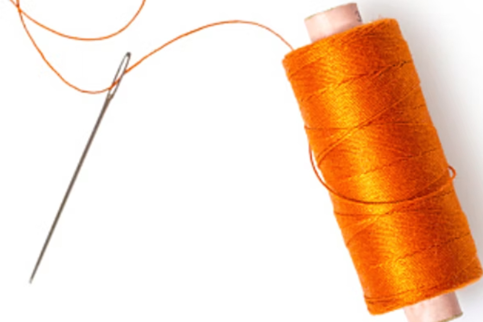An Orange Spool of Thread With A Sewing Needle On White Background