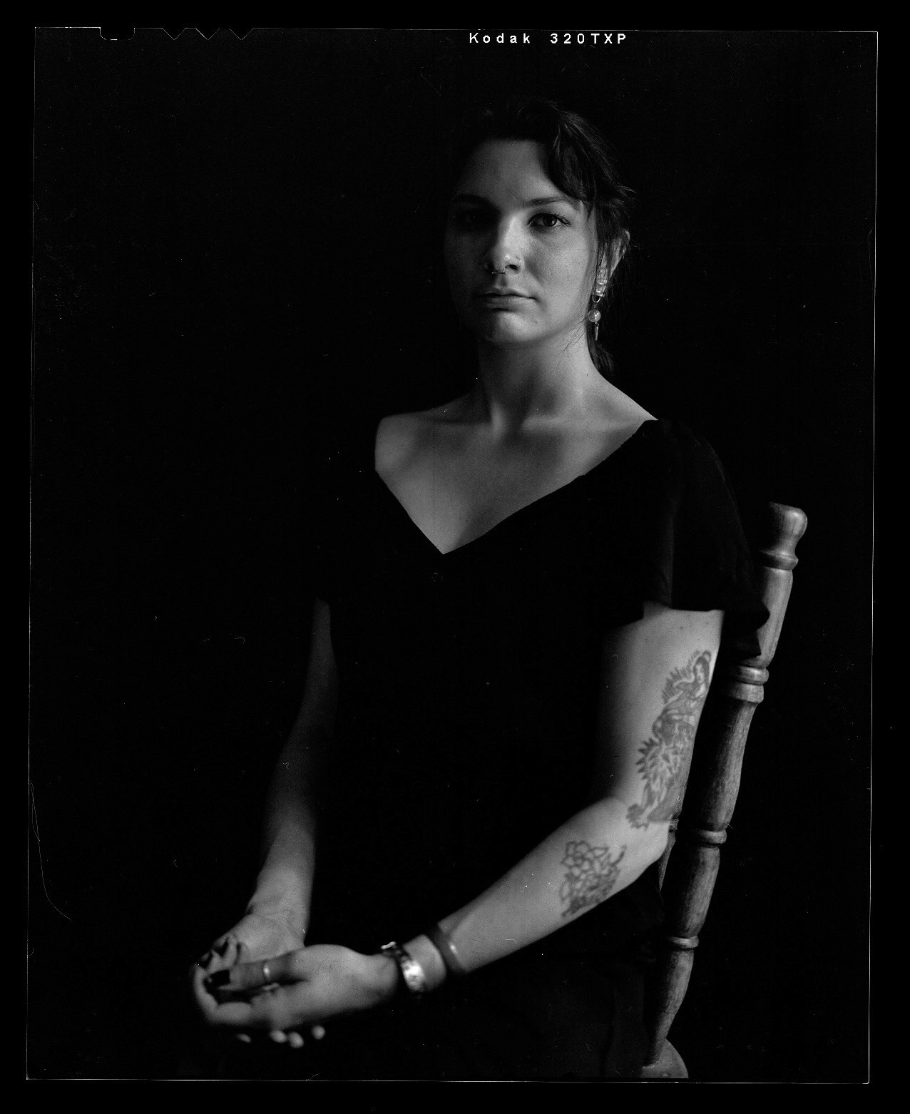 Black And White Portrait Of Allegra Hangen Sitting The Background Is Black