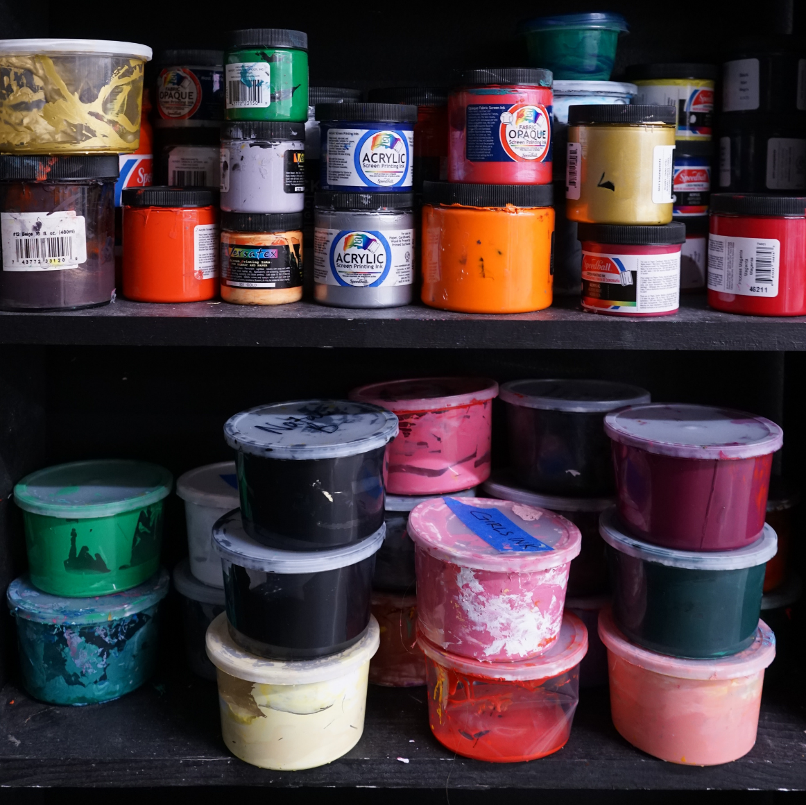 Co Op Supplies Several Jars of printers ink lined up on black shelves