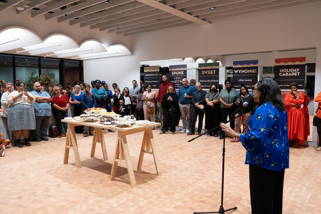 Kathy Tyree addresses a crowd in the lobby space during the theater dedication event