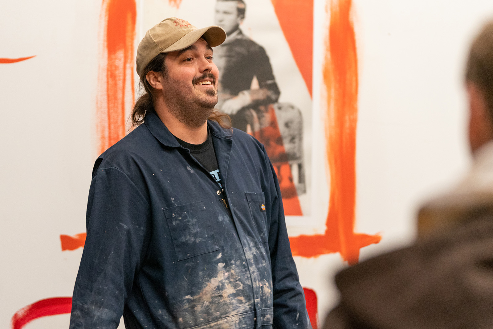 Nathaniel Ruleaux standing smiling in front of his work
