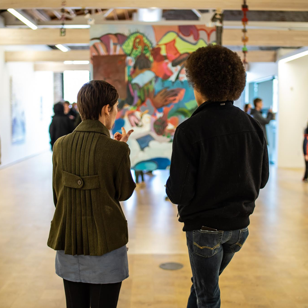 Photo of two people in the gallery looking at a painting during a gallery field trip