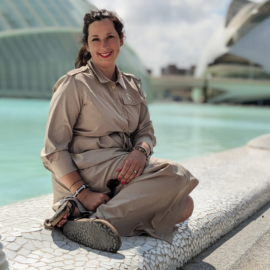 Populus Fund Grantee Carol Flora sits on the ledge of a shallow decorative pool