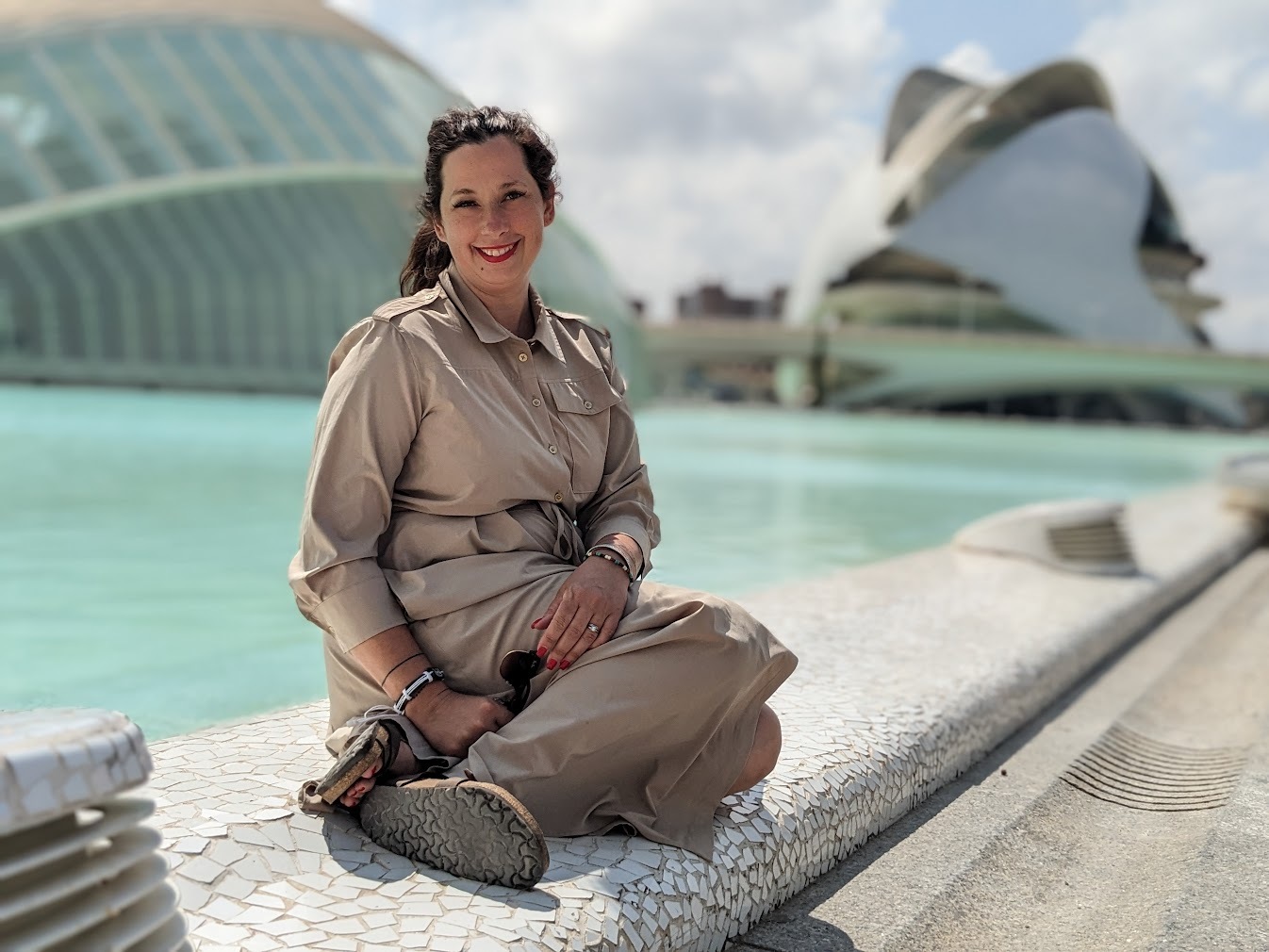 Populus Fund Grantee Carol Flora sits on the ledge of a shallow decorative pool