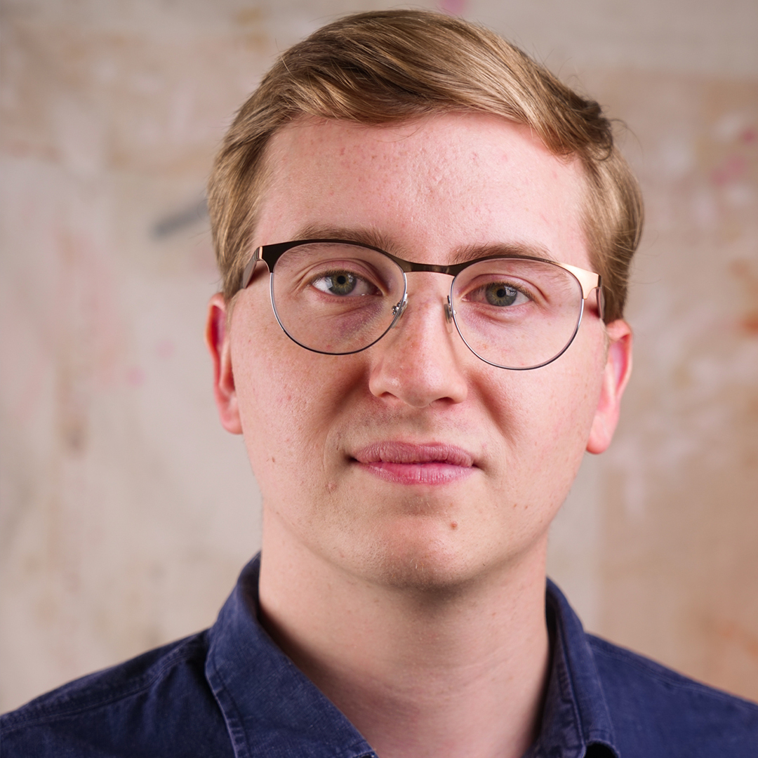 Populus Fund Grantee Nick Beaulieu looks at the camera in front of a bright abstract background