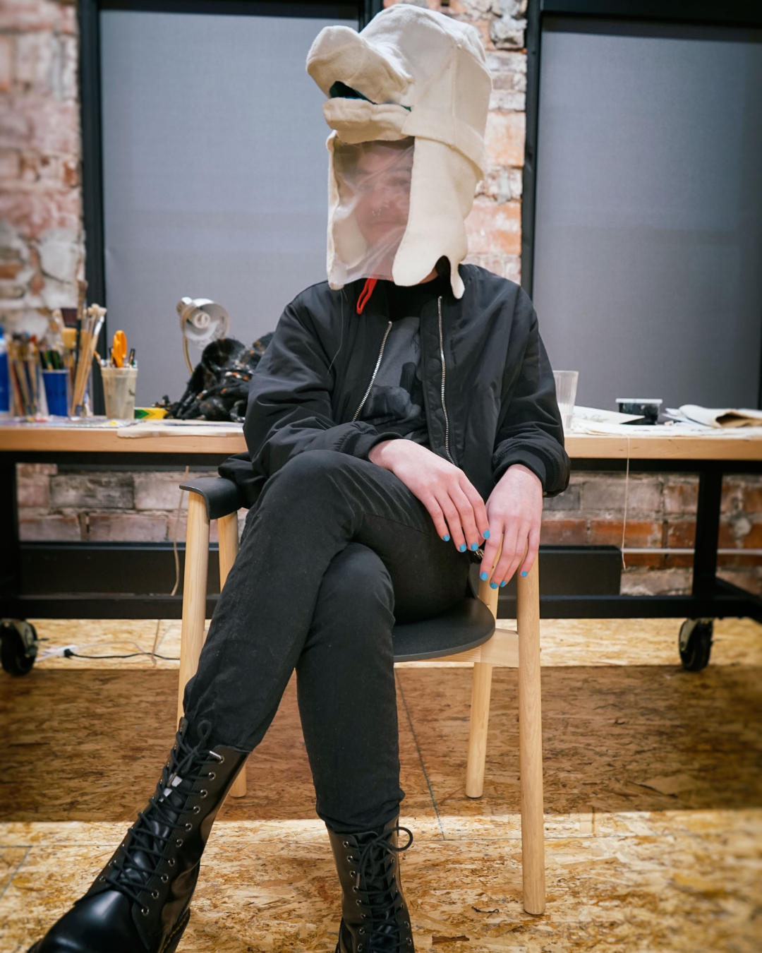 Portrait of Michael Johnson sitting in his Union studio wearing a fabric Wiggle Bird mask on his head