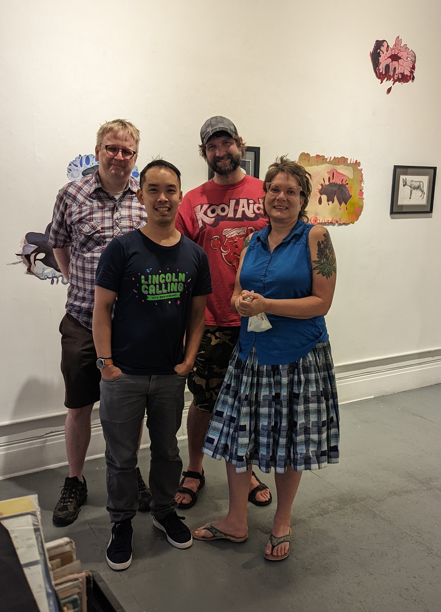 Tugboat Gallery Co Captains Keith Buswell Nolan Tredway Toan Vuong and Peggy Gomez Stand In Front of A Gallery Wall