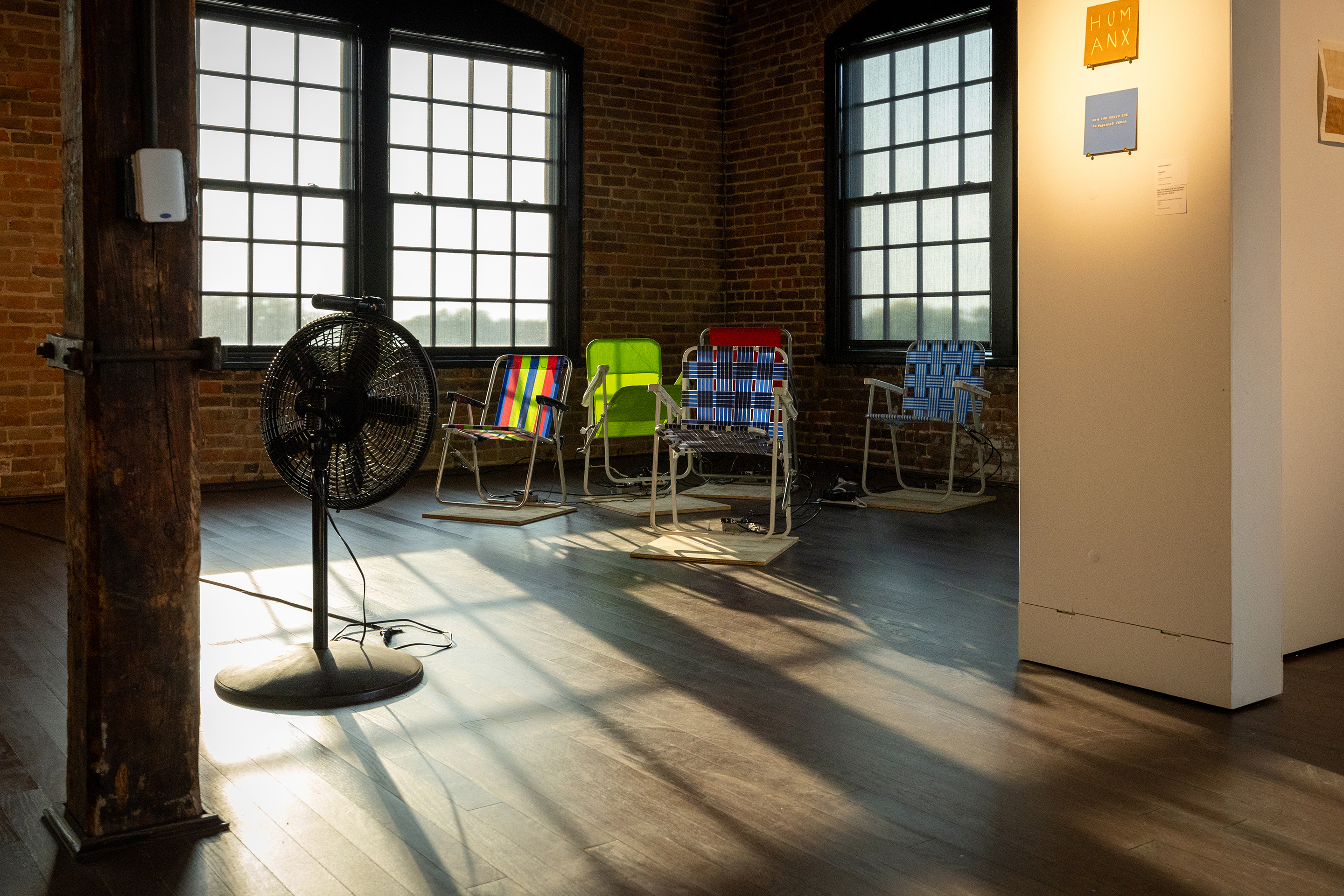 Wide shot of Fortuna group exhibition featuring an instalation colorful folding chairs Photo by Joey Carter