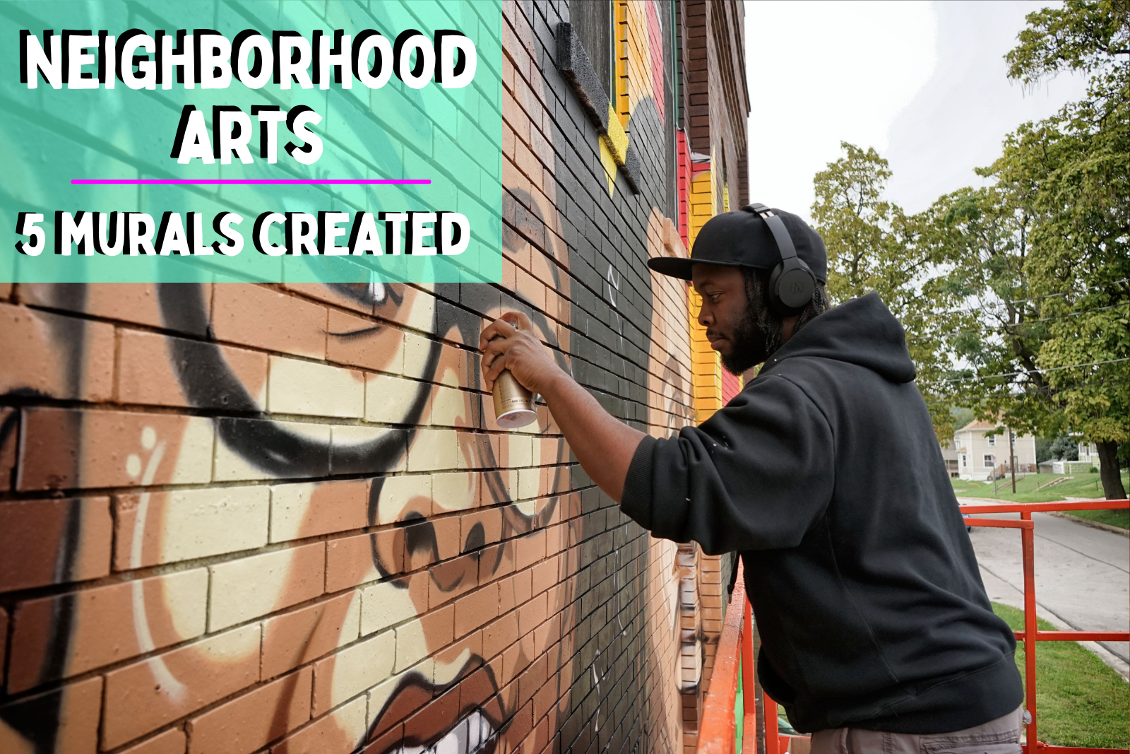 Neighborhood arts 5 murals created photo of artist Reggie Le Flores at work spray painting a wall